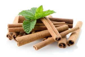 Cinnamon sticks on white reflective background.